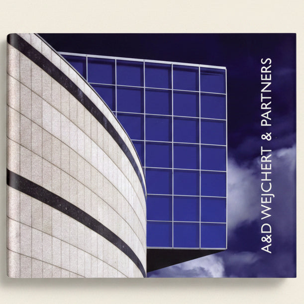 Modern architectural design with blue glass facade and white stone facade, featuring the brand 'A&D Weichert & Partners'.