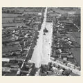 Aerial view of a residential area with rows of houses on either side of a street.
