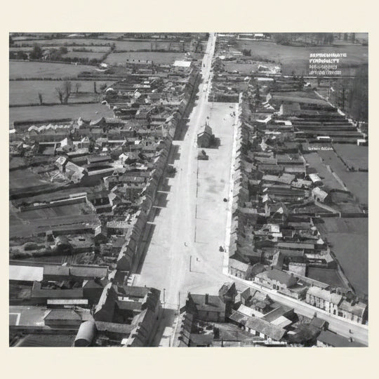 Aerial view of a residential area with rows of houses on either side of a street.