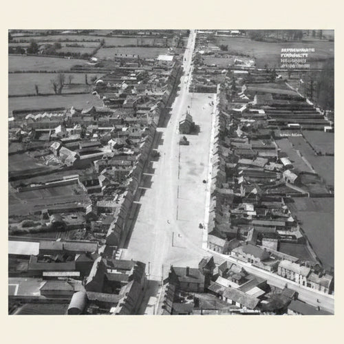 Aerial view of a residential area with rows of houses on either side of a street.