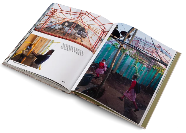 An open hardcover book photographed on a clean white background, showing two interior pages with architectural and lifestyle photographs.