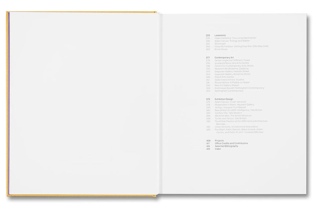An open hardcover book shown from above, with a blank white left page and a printed table of contents on the right page. The book has a thin gold or mustard-colored edge along the spine and cover.