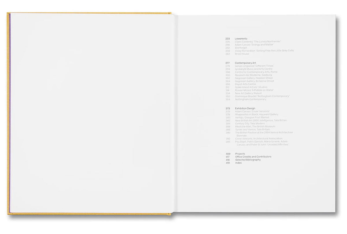 An open hardcover book shown from above, with a blank white left page and a printed table of contents on the right page. The book has a thin gold or mustard-colored edge along the spine and cover.