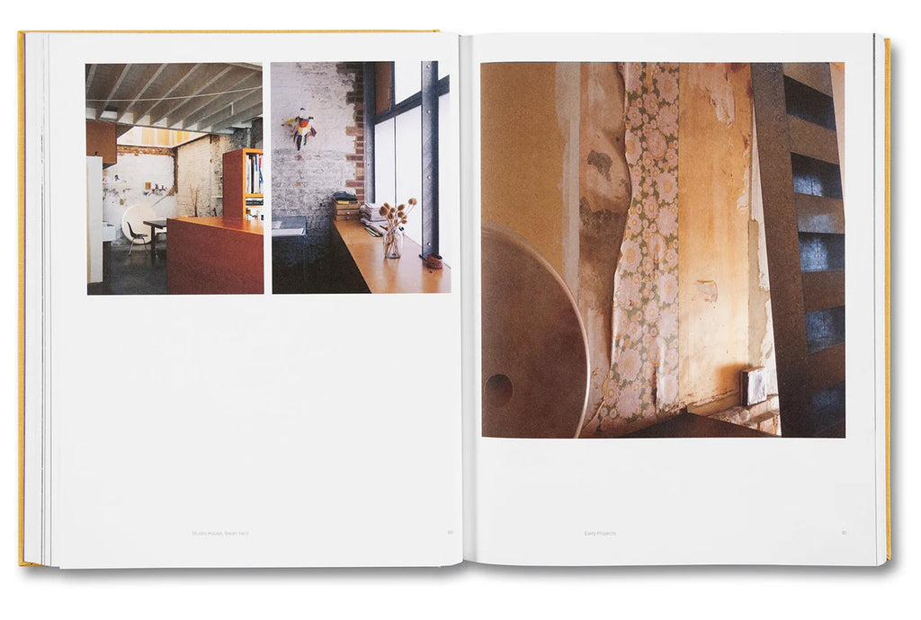 An open book or magazine spread showing interior architectural photographs printed on the pages, photographed against a plain white background.