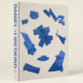 Book cover with blue geometric shapes on a beige background