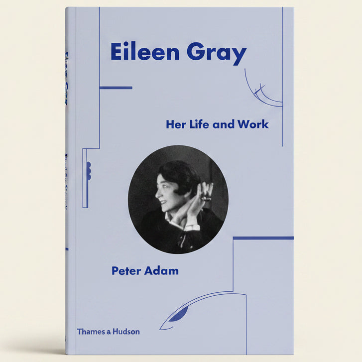 Book cover of 'Eileen Gray: Her Life and Work' by Peter Adam with a portrait of Eileen Gray on a light blue background.