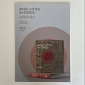 The front cover of the book 'Irish Cities in Crisis: Abridged' is shown against a plain light background. The cover is light gray with black text and a large muted pink circular graphic behind a smaller inset image of the book with a red circular emblem.