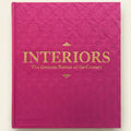 Pink book titled 'Interiors: The Greatest Rooms of the Century' with gold text.