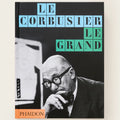 Book cover of 'Le Corbusier Le Grand' with a black and white photo of Le Corbusier and colorful text.