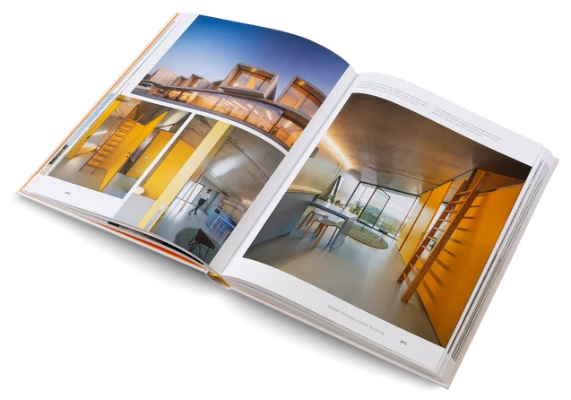 An open architectural photography book displayed at an angle on a clean white background, showing two spread pages with interior design and architecture images.