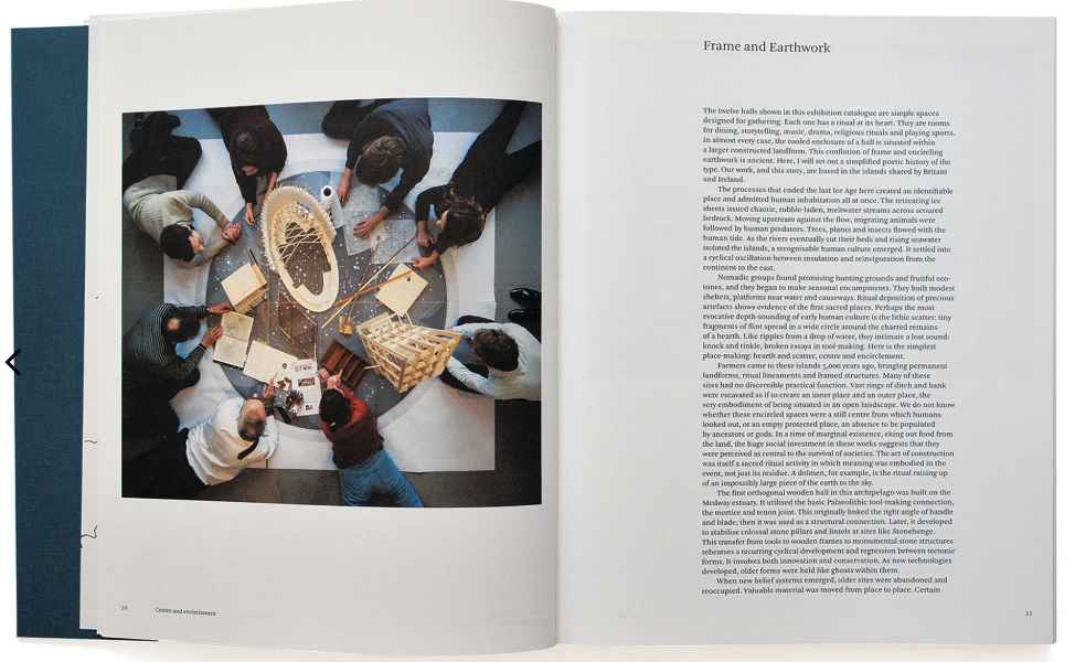 An open book spread showing a large photograph of people gathered around a circular table on the left page and a text column headed 'Frame and Earthwork' on the right page.