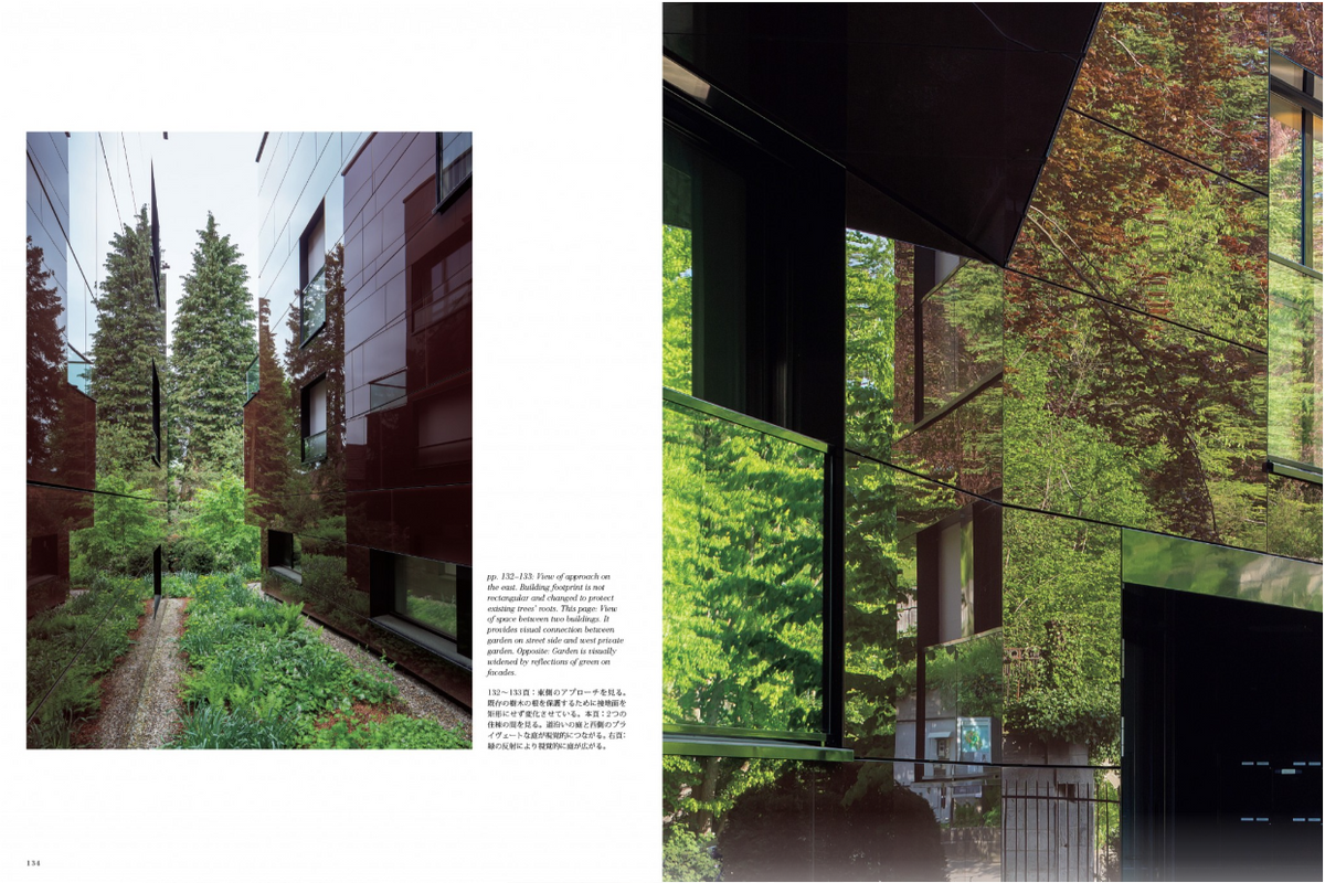A two-page spread from an architectural magazine or book, featuring a photograph of a modern building with reflective glass and lush green trees, accompanied by Japanese text.