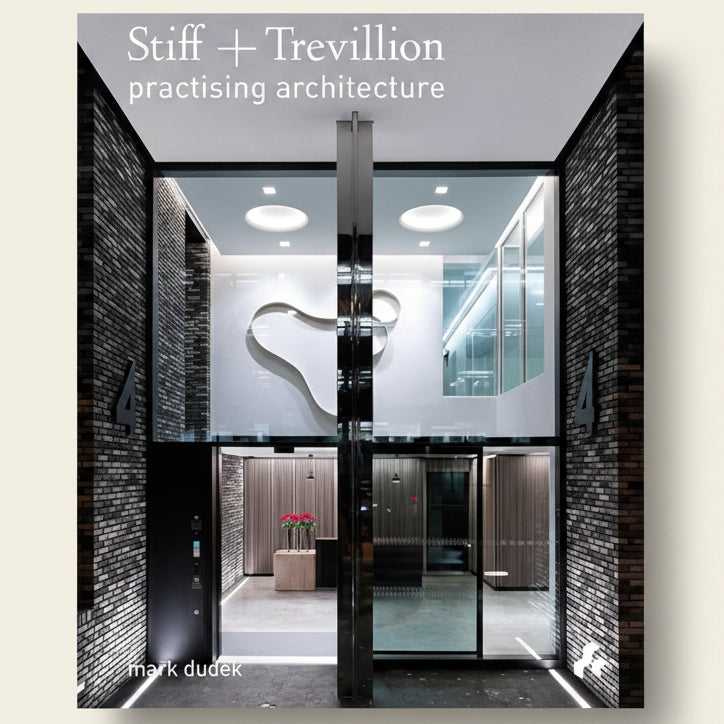 Modern architectural interior with glass walls and ceiling lights, featuring 'Stiff + Trevillion practising architecture' branding.