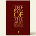 Book cover of 'The Eyes of the Skin' by Juhani Pallasmaa with gold text on a red background.