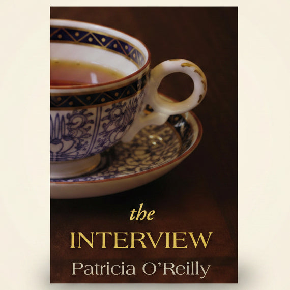 Teacup with saucer on a wooden surface, with 'The Interview' by Patricia O'Reilly.