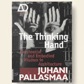 Book cover of 'The Thinking Hand' by Juhani Pallasmaa with a black and white photo of hands covering faces.