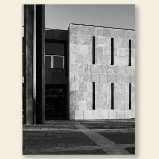 Black and white architectural photograph of a building with a textured wall.