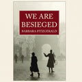Book cover of 'We Are Besieged' by Barbara Fitzgerald with a black and white scene of people walking.