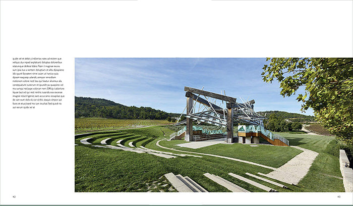A printed page from a book or magazine featuring a landscape photograph of an outdoor architectural structure on a grassy hill under a blue sky, with a large block of text on the left side and a muted green border around the page.